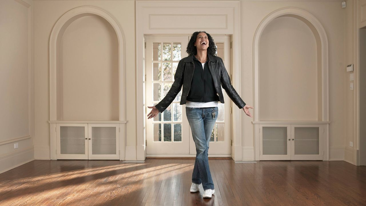 A young woman celebrates inside her new home.