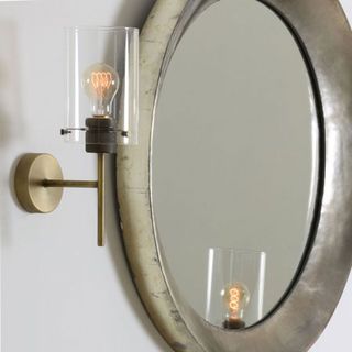 mirror on wall with wall light and glass encasing