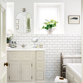White bathroom with metro wall tiles and cream vanity unti