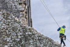 Conservators on their ropes to get to the walls of the castle. Credit: Neil Davidson/National Trust