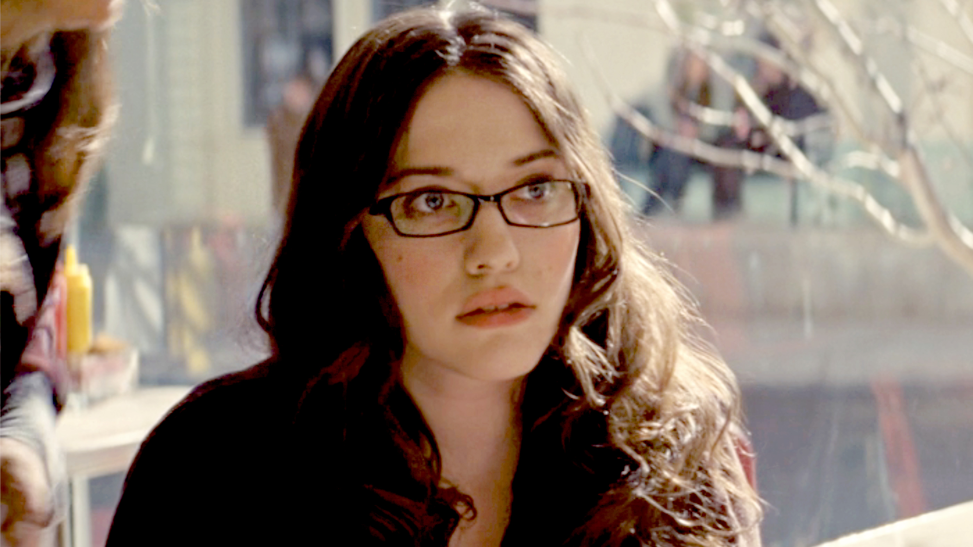 Kat Dennings, wearing a dark red top and glasses in Thor (2011).