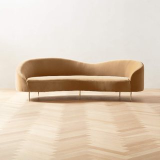 Curved tan velvet sofa by Goop.