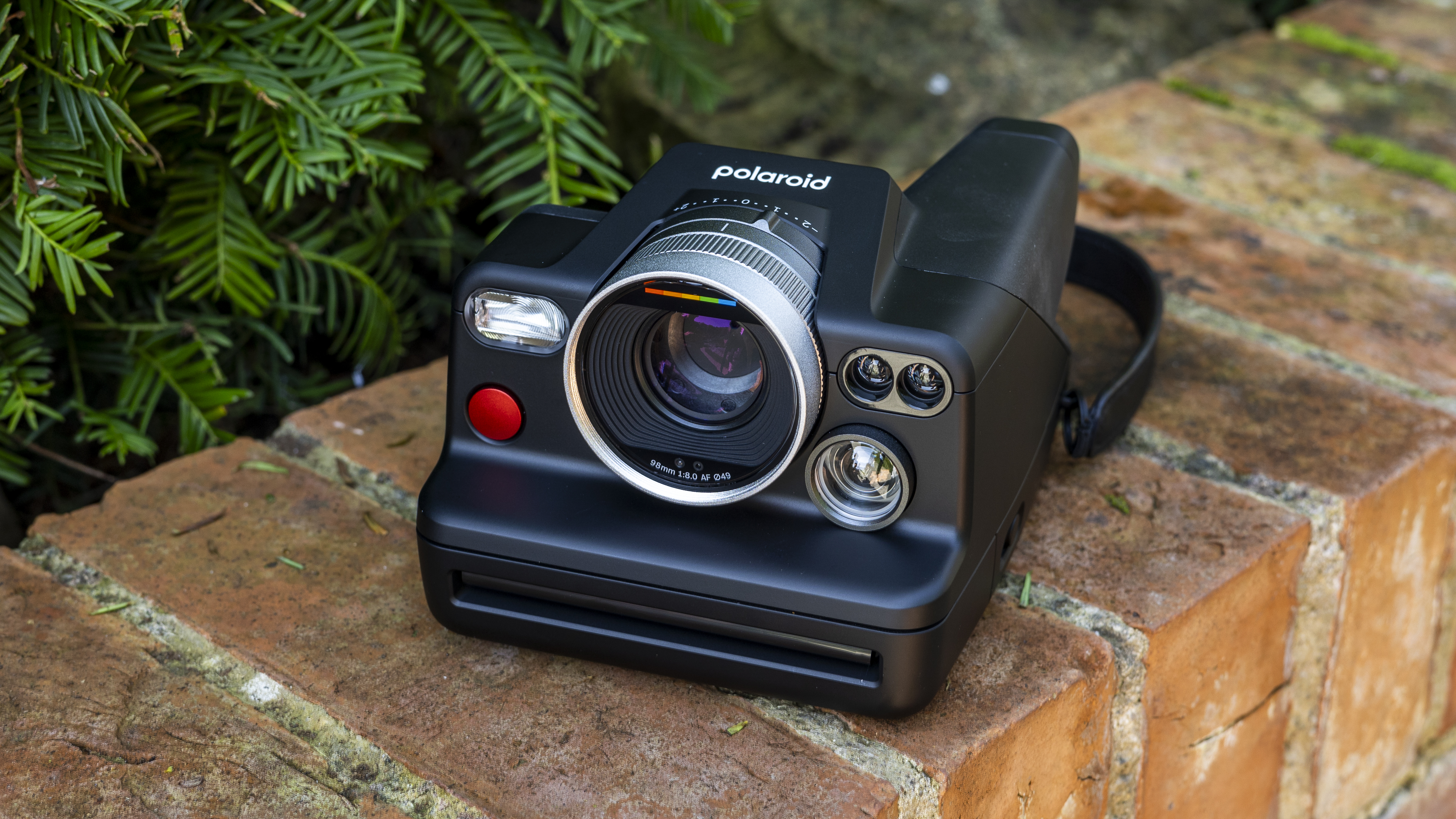 The Polaroid I-2 instant camera on a brick wall in the sunshine