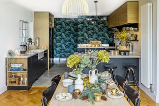 open-plan kitchen diner with botanical wallpaper oak wall cupboards and black base units