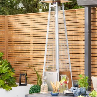 Patio heater by wooden garden fence