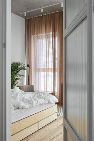 A neutral bedroom with storage under the bed