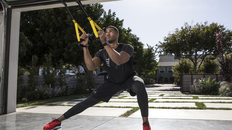 best suspension trainers: Pictured here, an athletic person doing side lunges using the TRX HOME2 suspension trainer