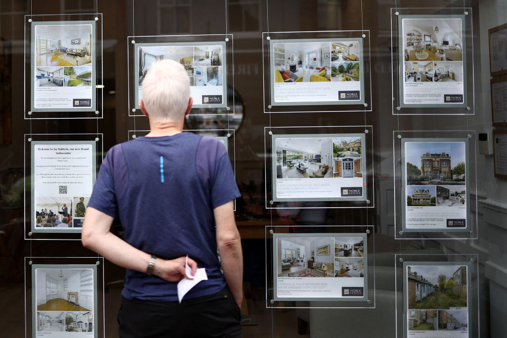 Person looking at the window of an estate agent