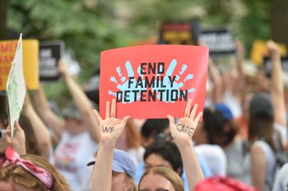 A protestor holds a sign demanding an end to the separation of migrant children from their parents.