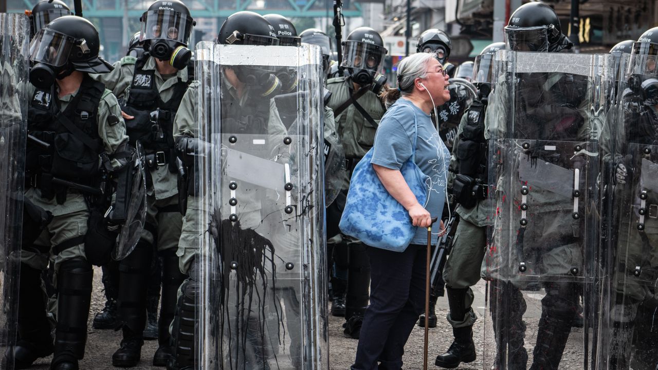 A woman shouts at police officers as they advance towards protesters in Hong Kong