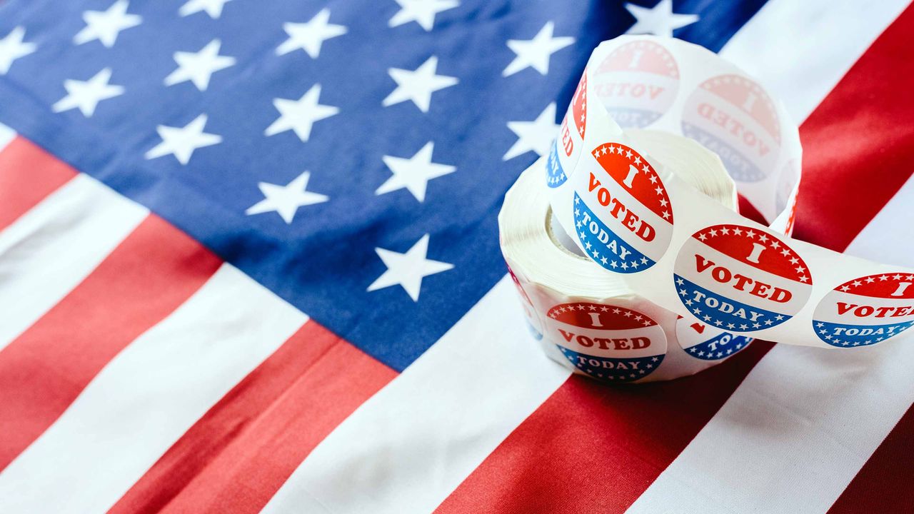 roll of &quot;I voted&quot; stickers on American flag