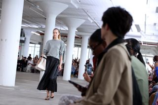 a model walks the tibi runway wearing a canvas tibi llbean bag accessorized with a black belt