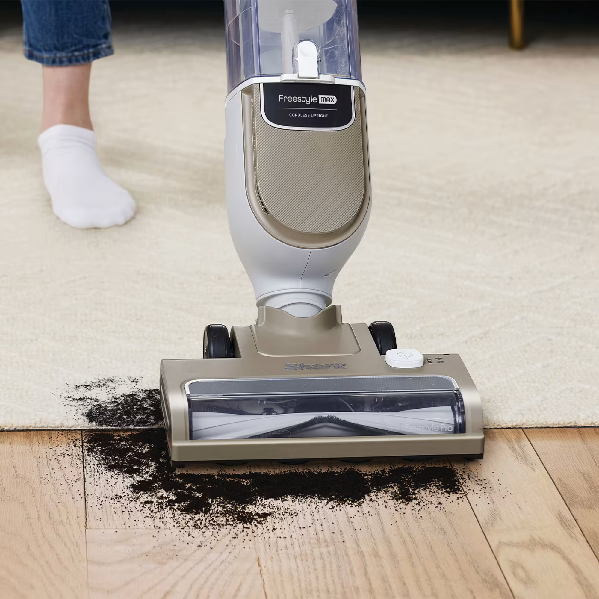 Shark Freestyle Pro floorhead cleaning up dirt from wooden floors and a rug