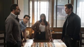 Karadec and Wagner standing across a table from each other while Oz and Daphne watch in High Potential Season 2