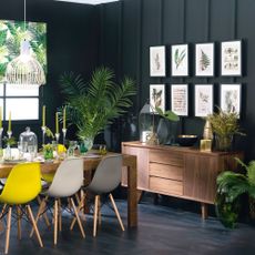Black dining room with wall panelling, gallery wall and botanical theme