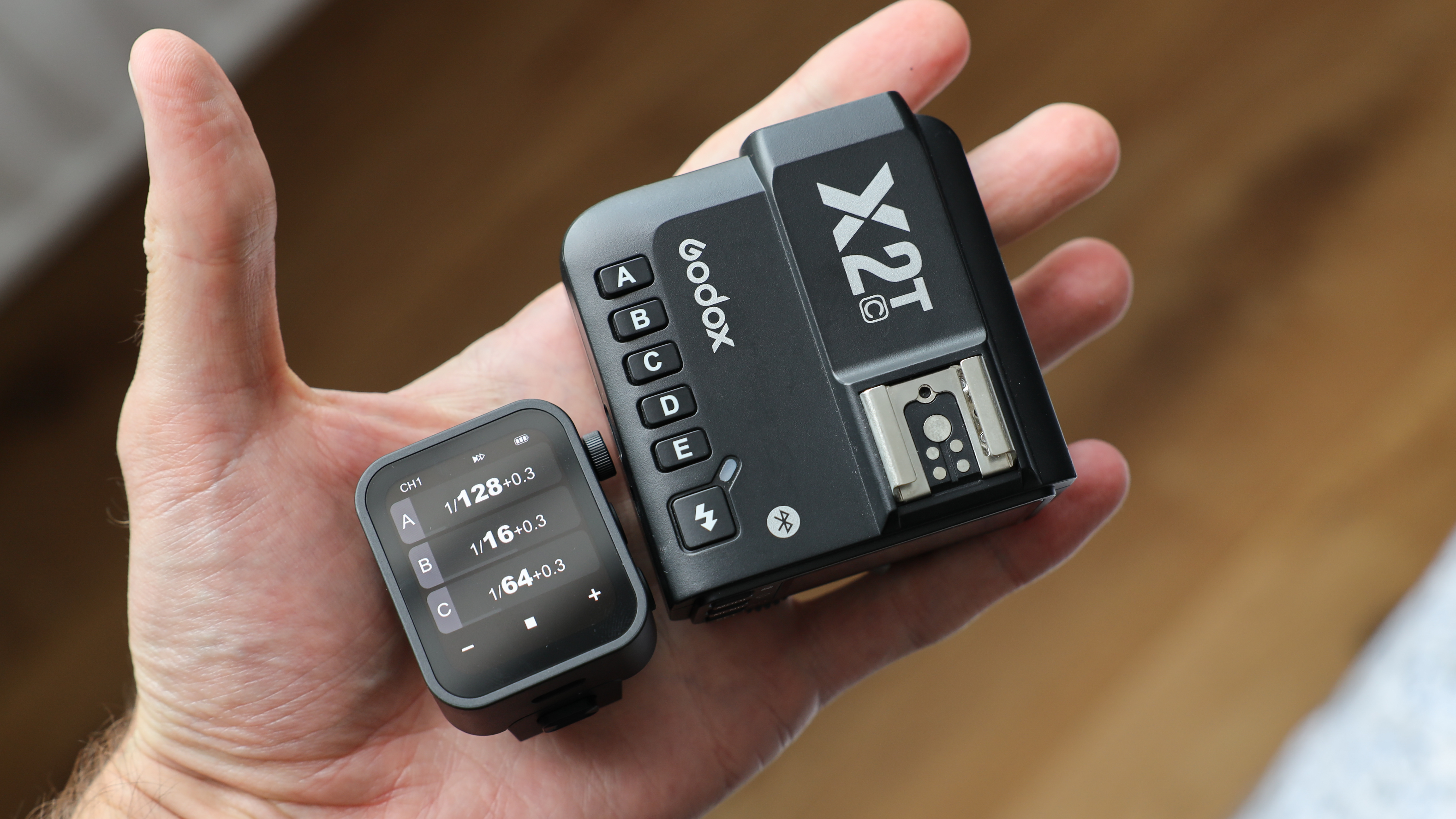 Godox X3 flash trigger next to and X2T trigger held in a hand