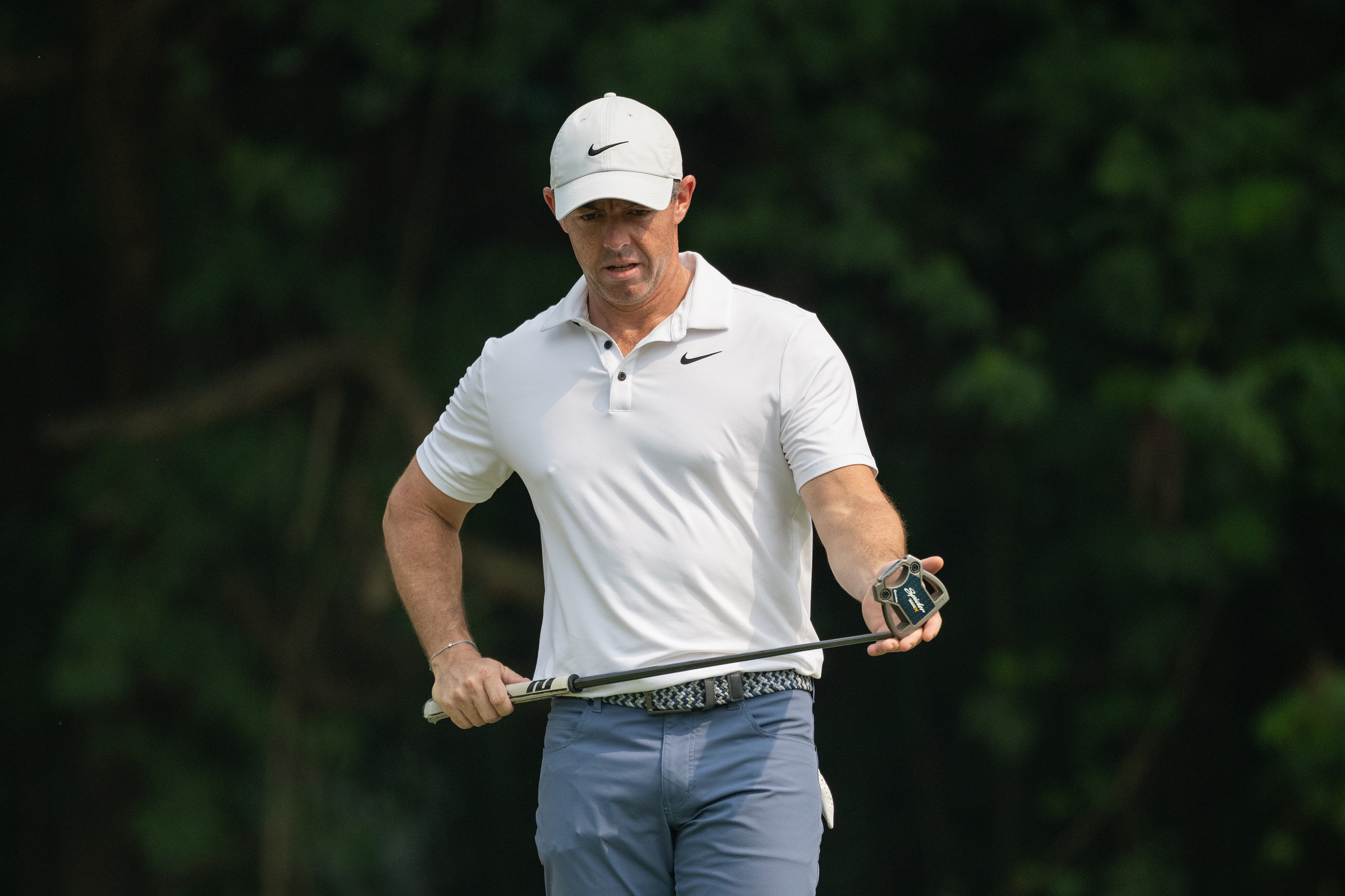 Rory McIlroy cleans the club face of his putter
