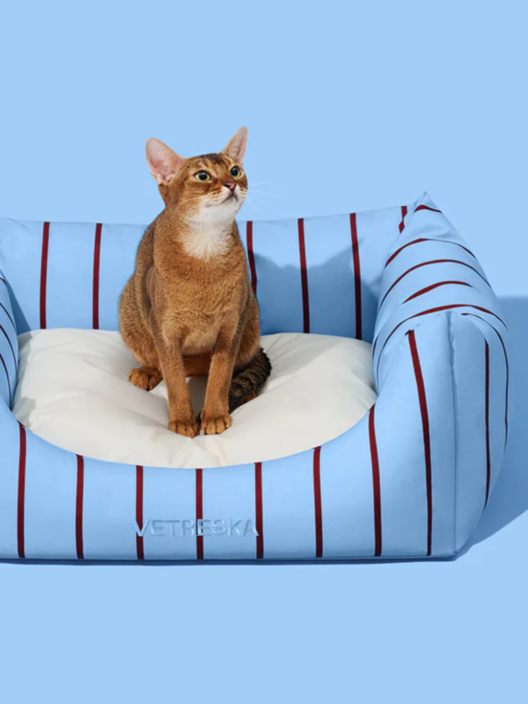 A striped pet sofa with a cat on it from VETRESKA