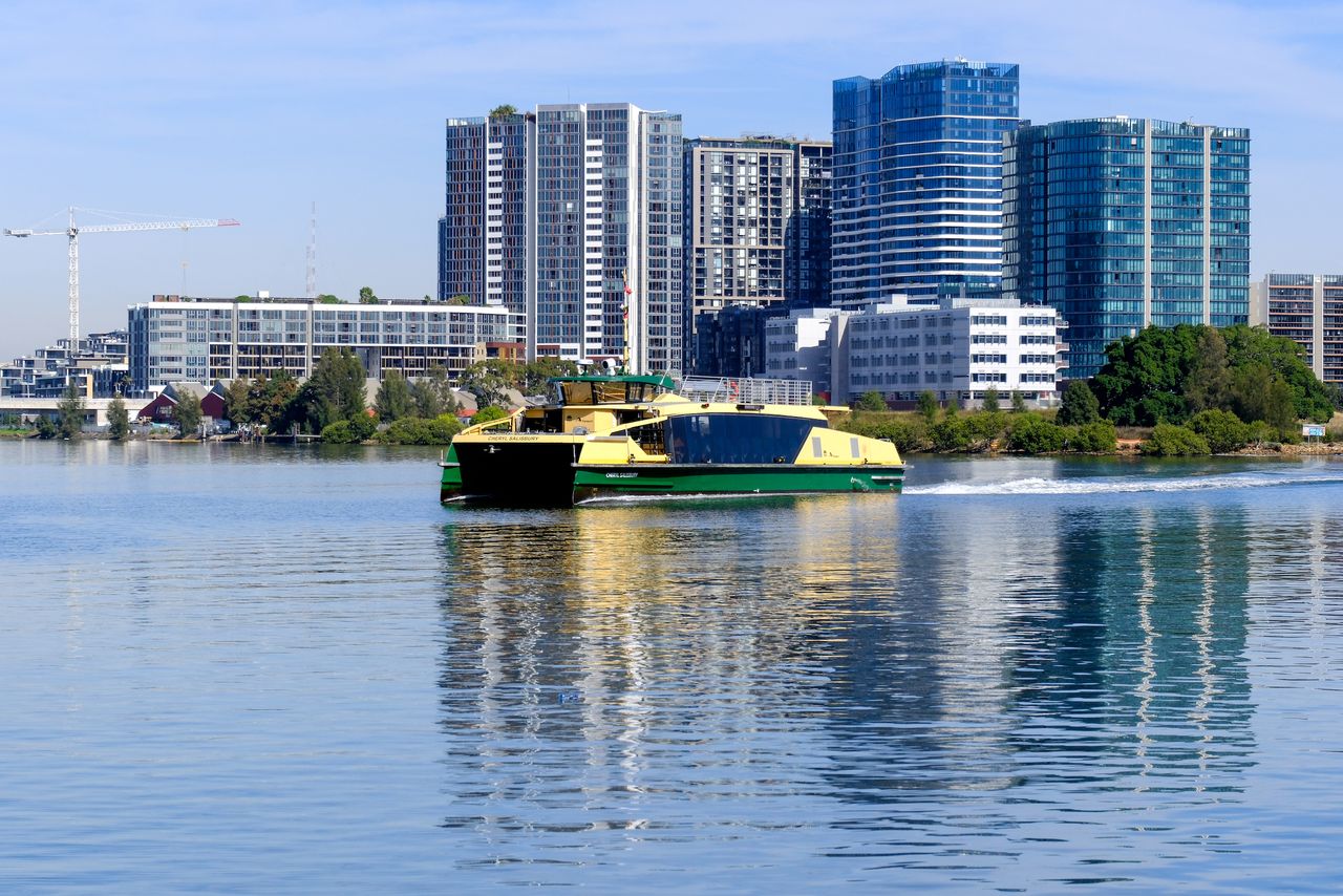 A green and yellow ferry on a river