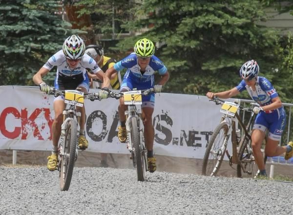 One the final lap, the crowd expects to see Georgia Gould come in solo, but she's hit a rock and can't fix the flat, so comes running around the final turn with her teammates Catharine Pendrel and Katerina Nash on her heels.
