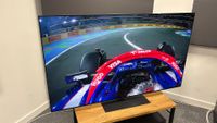 The 65-inch LG G5 OLED TV pictured on a wooden rack. On the screen is a still from Netflix F1 series Drive to Survive.