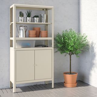 balcony with plant, cream metal storage unit with pots and garden tools