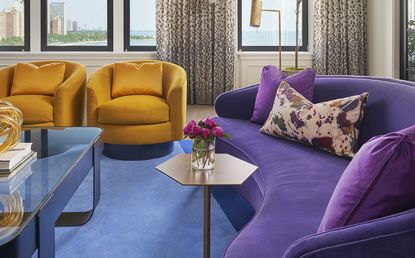 summer color palette for a living room with mustard chairs, purple sofa and blue rug