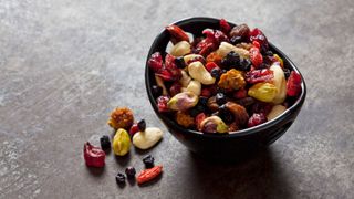 Bowl of dried fruit, including cranberries and raisins, with some nuts