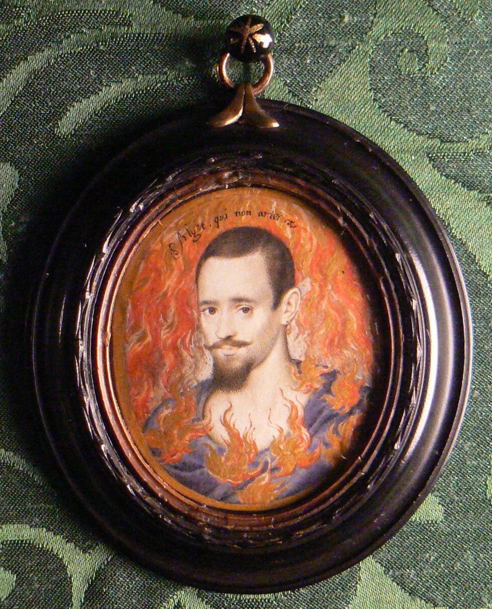 Portrait miniature, tempera on vellum stuck to card extended by another piece of card glued to support the back, presumably to fit the miniature into its frame (oval), A Man consumed by Flames by Isaac Oliver (Rouen c.1565 ? London 1617). Inscribed above his head: Alget qui non ardet (he becomes cold who does not burn). Apparently was written on the back: Earl of Leicester, but Horace Walpole wrote: &quot;But not the least like him, more like Lord Herbert [of Cherbury].&quot; A head-and-shoulders portrait of man with close-cut black hair, spade beard and moustache, turned slightly to the left, gazing at the spectator, surrounded by a circle of flames consuming his antique slate-blue robe and the background. The &#039;Impresa&#039; device as elucidated by Roy Strong in his work &quot;Portrait as Impresa&quot; suggests it would have been given as a love token. The lover burning up in the flames of his own passion is a familiar symbol in sixteenth-century love poetry. The identification of the portrait miniature with Robert Devereux, 2nd Earl of Essex, KG (1566 - 1601) is also plausible.