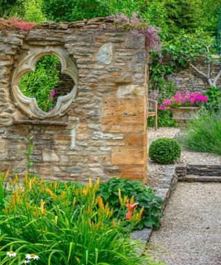reclaimed stone wall used to divide areas of a garden