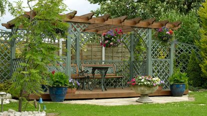 A wooden pergola next to a fence