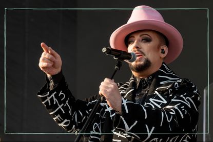 Boy George on stage singing into a microphone