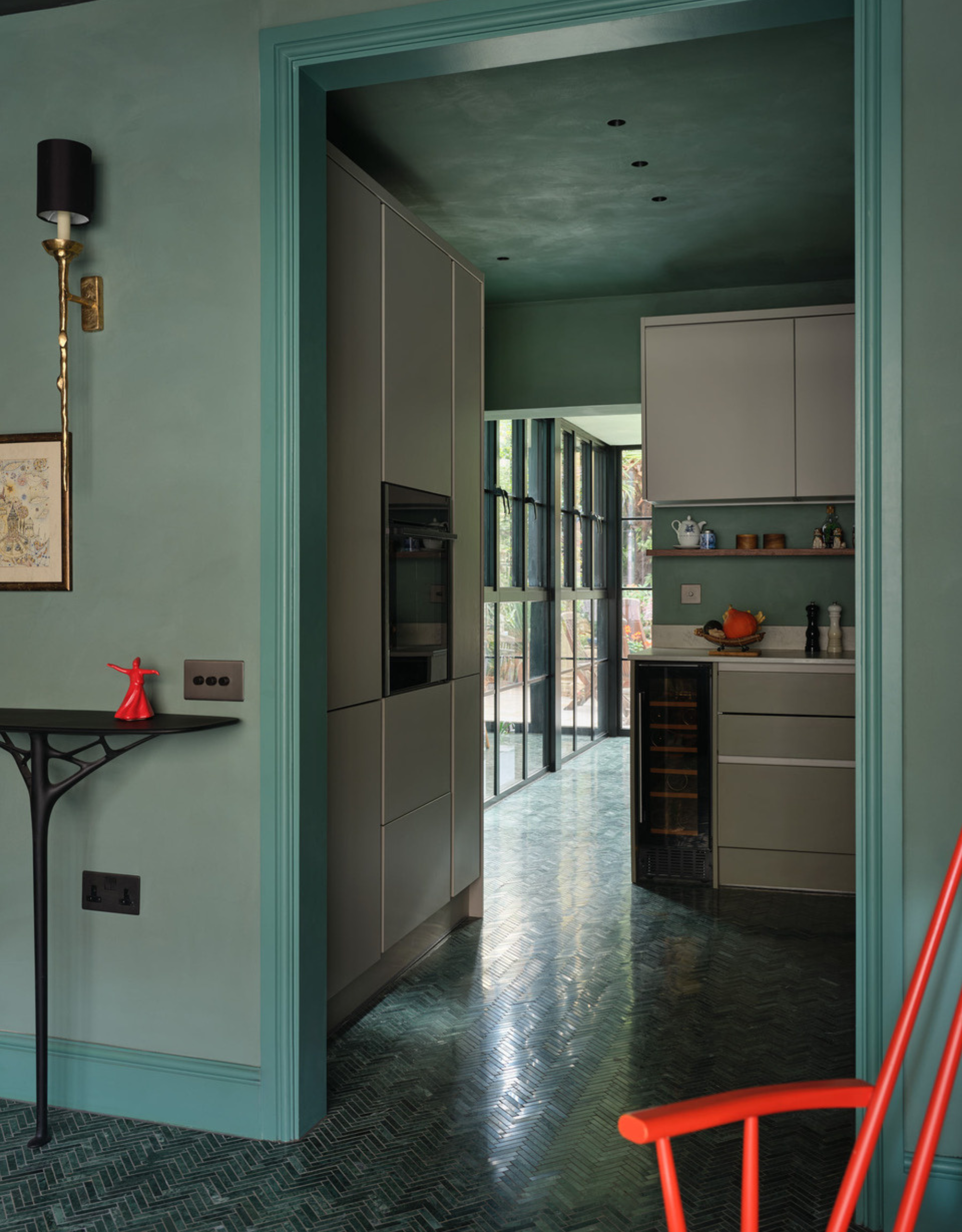 An aquamarine small kitchen with white cabinets