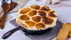A browned marshmallow topping in a black cast iron skillet
