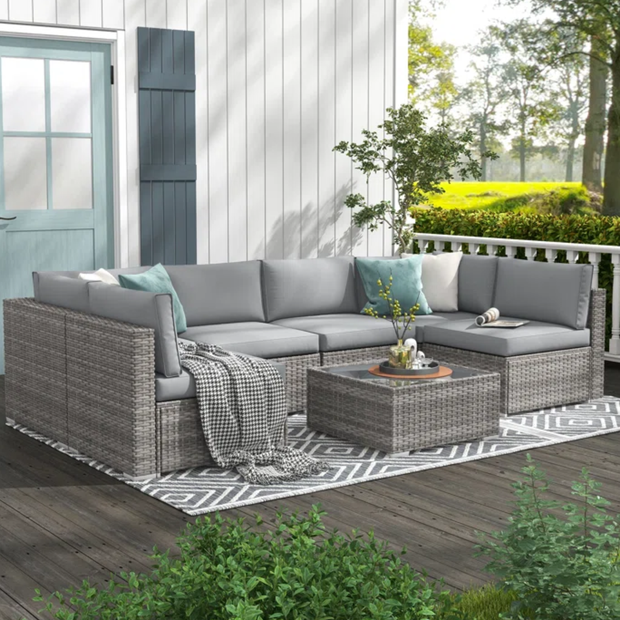 a gray outdoor couch on a patio next to a house