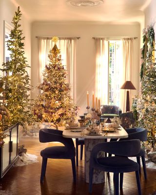 a dining room decorated for Christmas with Christmas trees