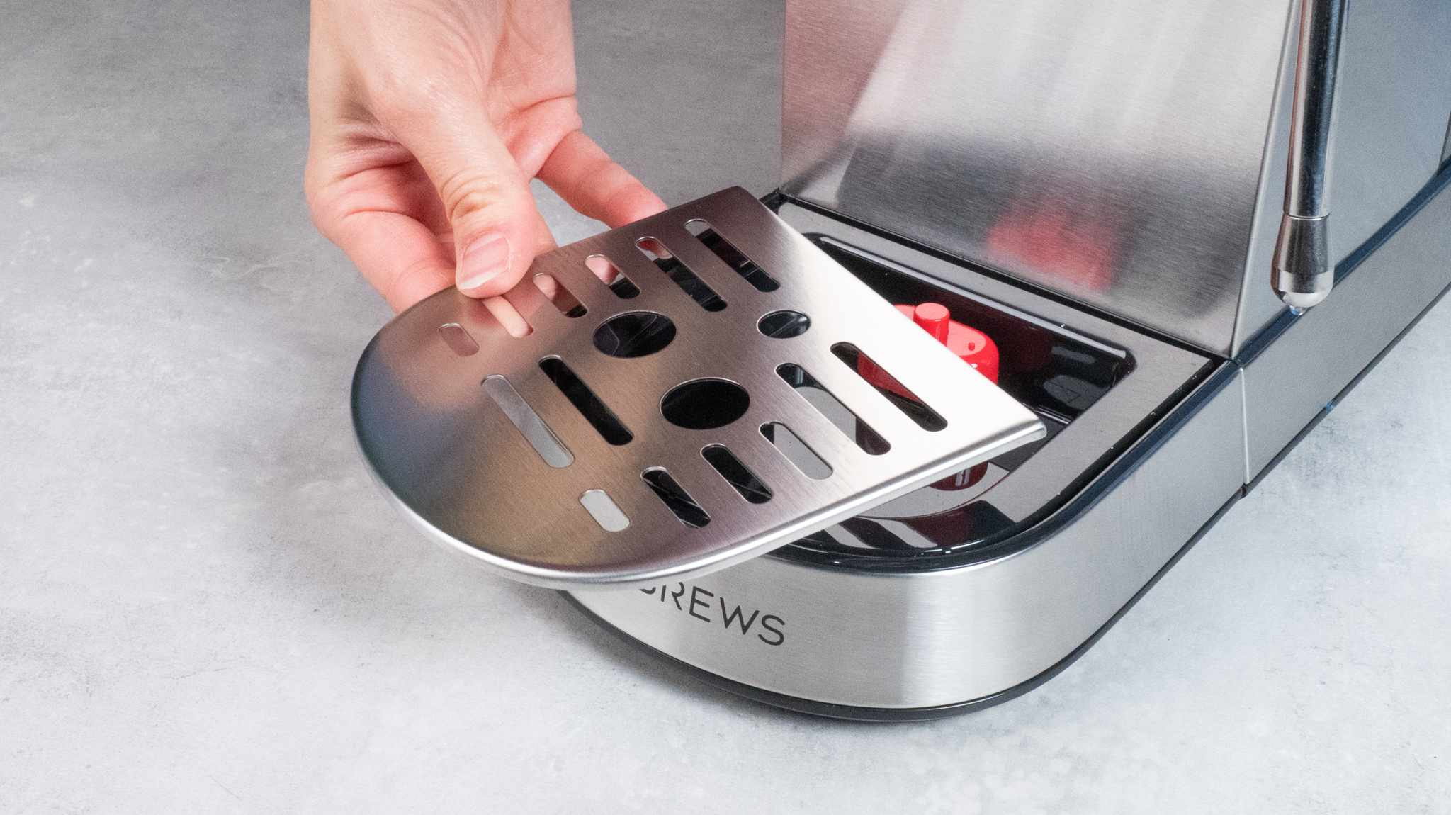 The Casabrews 5418 Pro espresso machine in stainless steel with a steam wand on the right side and three buttons on the front of the machine and a pressure gauge underneath