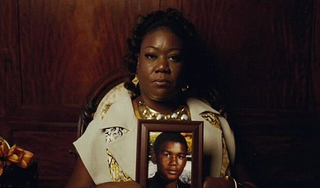 Trayvon Martin's mother holds a photo of him