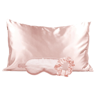 A blush pink satin pillowcase, eye mask, and scrunchie
