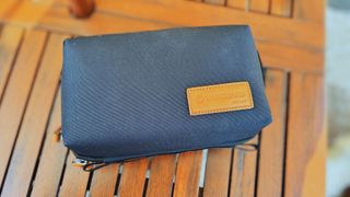 A blue-grey VEO City Bag Technical Pack sitting on a wooden garden table