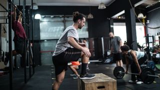 Man performs step-up exercise in gym
