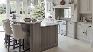 traditional pale gray kitchen with kitchen island with sink opposite oven as part of the work triangle to avoid kitchen design mistakes