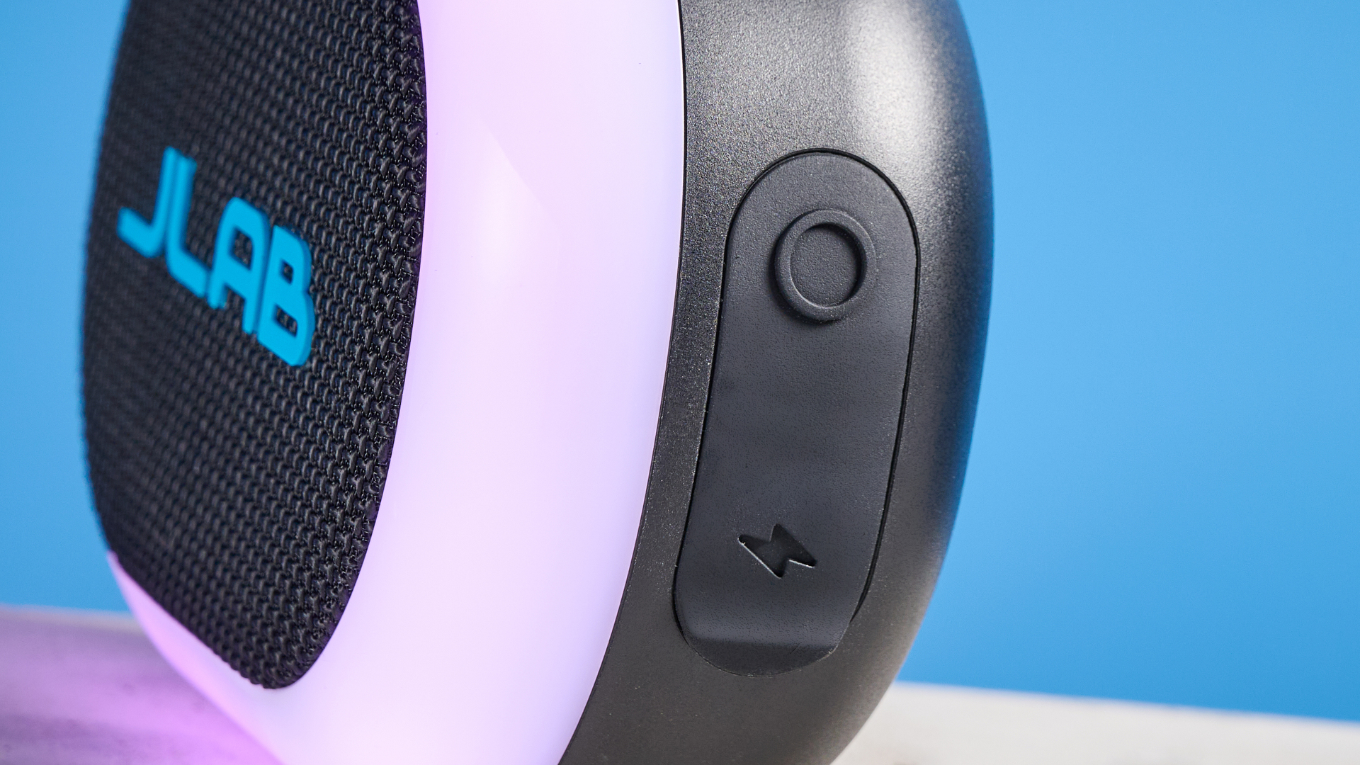 JLab Pop Party portable Bluetooth speaker with RGB lighting photographed on a blue background.