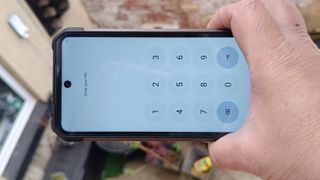 Hand holding a phone that requires a PIN to operate