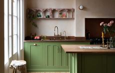 a green kitchen with pink plaster walls