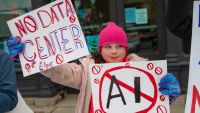 Young girl holding anti-ai signs at a protest.