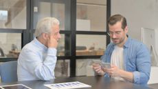 Older man giving younger man money