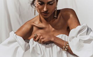 Model wears white off the shoulder dress and Goossens bridal jewellery