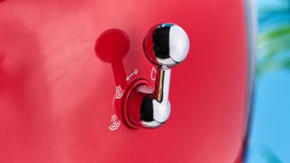 a red smeg espresso machine with burr grinder is photographed against a blue background