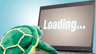 Turtle plush doll in front of a laptop with a loading screen to indicate slow internet